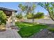 Spacious backyard featuring well-maintained lawn, stone patio, mature trees, and rock landscaping, perfect for outdoor activities at 8336 S Homestead Ln, Tempe, AZ 85284