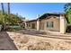 The backyard shows the structure of the home with windows and doors with a large area of mulch to be re-landscaped at 8336 S Homestead Ln, Tempe, AZ 85284