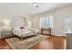 Bright bedroom featuring hardwood floors, a wrought iron bed frame, and large windows with wooden shutters at 8336 S Homestead Ln, Tempe, AZ 85284