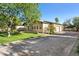 Attractive home exterior with a well-maintained lawn, mature trees, and a spacious driveway leading to a three car garage at 8336 S Homestead Ln, Tempe, AZ 85284