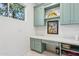 Well-lit laundry room with custom blue cabinetry and bright white countertops at 8336 S Homestead Ln, Tempe, AZ 85284