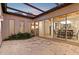 An outdoor patio with a clear roof lets in sunlight, while a dining table inside is visible through sliding glass doors at 8336 S Homestead Ln, Tempe, AZ 85284