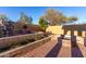 Intimate backyard with brick paver patio, multiple planter boxes, and a built-in fire pit at 8542 E Indigo St, Mesa, AZ 85207