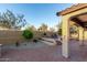 Covered backyard patio with brick pavers, outdoor furniture, and landscaping at 8542 E Indigo St, Mesa, AZ 85207