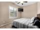 Cozy bedroom featuring a window with blinds, a ceiling fan, and a mounted TV at 8542 E Indigo St, Mesa, AZ 85207