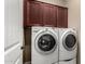 Laundry room featuring a washer and dryer with upper cabinets, and white trim at 8542 E Indigo St, Mesa, AZ 85207