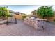Outdoor kitchen and grilling area on brick paved patio with seating at 8542 E Indigo St, Mesa, AZ 85207
