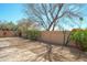Spacious backyard with desert landscaping, a paved patio, and mature trees, creating a serene outdoor retreat at 8877 E Riviera Dr, Scottsdale, AZ 85260