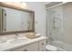 Bathroom featuring framed mirror and glass doored shower and tub at 8877 E Riviera Dr, Scottsdale, AZ 85260