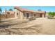 Back exterior featuring a covered patio, outdoor dining, desert landscaping, and neutral color palette at 8877 E Riviera Dr, Scottsdale, AZ 85260