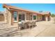 Back exterior with a paved patio, dining set, desert landscaping, and a tile roof, perfect for outdoor living at 8877 E Riviera Dr, Scottsdale, AZ 85260