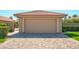 Beige two-car garage with a terra cotta roof and a paved driveway at 8877 E Riviera Dr, Scottsdale, AZ 85260