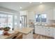 Modern kitchen featuring stainless steel appliances, white cabinets, and a large center island with bar stools at 8877 E Riviera Dr, Scottsdale, AZ 85260