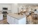 Modern kitchen with island, white cabinets, stainless appliances, and view into living area at 8877 E Riviera Dr, Scottsdale, AZ 85260