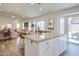 Open concept kitchen with white island, stainless appliances, and view to a sunlit living area at 8877 E Riviera Dr, Scottsdale, AZ 85260