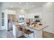 Contemporary kitchen with stainless steel refrigerator, white cabinets, and a large island with bar seating at 8877 E Riviera Dr, Scottsdale, AZ 85260