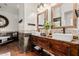Bathroom featuring double vanity sinks, stone accents, and rustic cabinetry at 9401 N 122Nd Pl, Scottsdale, AZ 85259