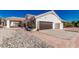 Exterior view of the home featuring a two-car garage, desert landscaping and gravel driveway at 9401 N 122Nd Pl, Scottsdale, AZ 85259