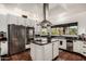 Modern kitchen featuring stainless steel appliances, an island cooktop, and ample counter space for culinary creations at 9401 N 122Nd Pl, Scottsdale, AZ 85259
