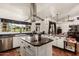 Modern kitchen featuring dark countertops, stainless steel appliances, and an island cooktop at 9401 N 122Nd Pl, Scottsdale, AZ 85259