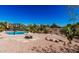 Desert backyard featuring pool, fire pit, basketball hoop, and lush desert landscaping at 9401 N 122Nd Pl, Scottsdale, AZ 85259