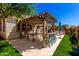 Charming back patio with a pergola, dining table, and lush greenery, perfect for outdoor gatherings at 10043 W Foothill Dr, Peoria, AZ 85383