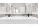 Modern bathroom featuring double sinks, neutral toned backsplash, and sleek white cabinetry at 10043 W Foothill Dr, Peoria, AZ 85383
