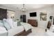 Bright bedroom with tile floors, chandelier lighting, and a modern barn door to the en suite bath at 10043 W Foothill Dr, Peoria, AZ 85383