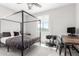 Bedroom with canopy bed, weights, desk, and natural light from the window at 10043 W Foothill Dr, Peoria, AZ 85383