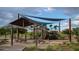 Community playground featuring shade covers, picnic tables, and diverse play equipment for children at 10043 W Foothill Dr, Peoria, AZ 85383