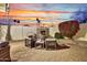 Backyard showing fireplace with patio seating surrounded by palm trees and desert landscaping at 11033 E Poinsettia Dr, Scottsdale, AZ 85259