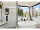 Bright modern bathroom featuring a soaking tub, glass shower and dual windows at 11033 E Poinsettia Dr, Scottsdale, AZ 85259