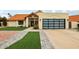Charming home showcasing a tile roof, modern garage door, desert landscaping, and inviting curb appeal at 11033 E Poinsettia Dr, Scottsdale, AZ 85259