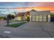 Charming home exterior with a well-manicured lawn, desert landscaping, and a view of the modern garage door at 11033 E Poinsettia Dr, Scottsdale, AZ 85259