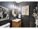 Stylish powder room with dark walls, modern lighting, artistic decor, and wood vanity at 11033 E Poinsettia Dr, Scottsdale, AZ 85259