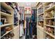 Organized walk-in closet with shelves, hanging rods, and storage baskets for optimal storage and access at 11033 E Poinsettia Dr, Scottsdale, AZ 85259