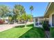 Scenic backyard showcasing green lawn and lush landscaping and enclosed patio at 12634 W Seneca Dr, Sun City West, AZ 85375