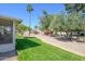 Lush backyard highlighting a screened patio, green lawn, and mature trees at 12634 W Seneca Dr, Sun City West, AZ 85375