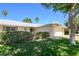 A bright, well-kept single-story home featuring lush green landscaping, decorative sun, and a shade tree at 12634 W Seneca Dr, Sun City West, AZ 85375
