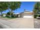 Charming single-story home with a well-manicured lawn and a two-car garage, set under a clear blue sky at 12634 W Seneca Dr, Sun City West, AZ 85375