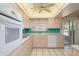 Kitchen with white appliances, ample counter space, light wood cabinets, and access to the patio at 12634 W Seneca Dr, Sun City West, AZ 85375