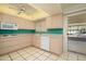 Bright kitchen with tile floors, light wood cabinets, blue backsplash, and access to the patio at 12634 W Seneca Dr, Sun City West, AZ 85375