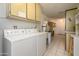 Bright laundry room featuring washer, dryer, sink, cabinets, and tiled floor at 12634 W Seneca Dr, Sun City West, AZ 85375