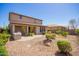 A spacious backyard with desert landscaping, rock ground cover, a covered patio, and an outdoor kitchen at 13660 N 144Th Ln, Surprise, AZ 85379