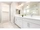 Bright bathroom featuring double sinks with a large mirror and a view into the tiled shower at 13660 N 144Th Ln, Surprise, AZ 85379
