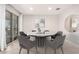 Modern dining room with round table, stylish chairs, decorative mirror and ample natural light at 13660 N 144Th Ln, Surprise, AZ 85379