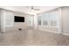 Bright living room with wood-look tile flooring, a ceiling fan, and multiple shuttered windows at 13660 N 144Th Ln, Surprise, AZ 85379