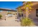 View of covered patio featuring built-in outdoor kitchen with grill, paver flooring, and desert landscaping at 13660 N 144Th Ln, Surprise, AZ 85379