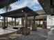 Outdoor dining area with tables, built-in benches, and stone accents under a pergola at 13660 N 144Th Ln, Surprise, AZ 85379