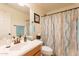 Well-lit bathroom featuring a vanity, mirror, and bathtub with a decorative shower curtain at 1374 E Linda Dr, Casa Grande, AZ 85122